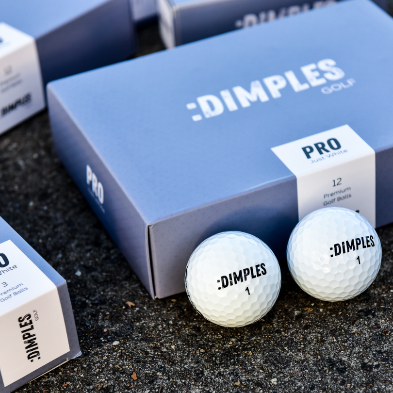 Dimples Pro White Golf Balls Placed Infront Of The Packaging